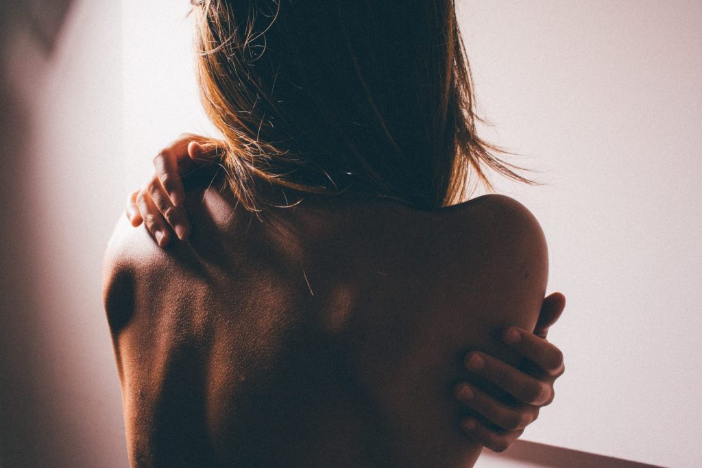 Das Bild zeigt eine Frau mit nacktem Rücken von hinten.