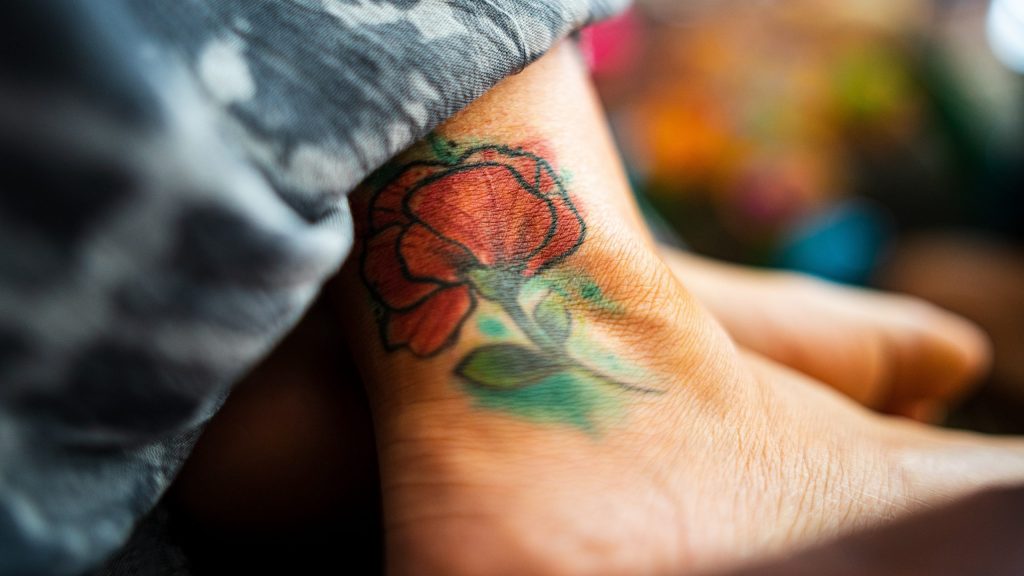 Das Bild zeigt einen Knöchel mit einer tattowierten Rose.